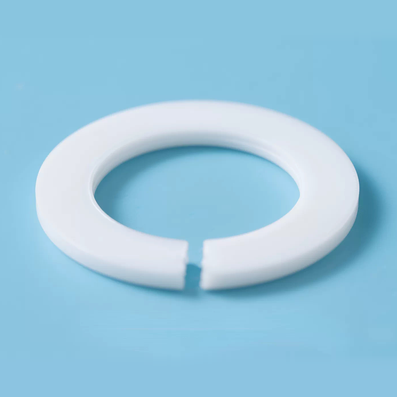 A low-angle view of a flat PTFE ring and its open ends